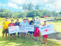 Families with signs welcoming their loved ones home