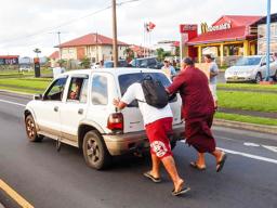 American Samoa Lieutenant Governor Lemanu pushing stalled car out of the way of traffic