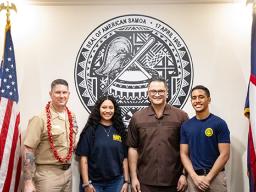 U. S. Navy Commander Robert L. Moran (left) and Lt. Gov Talauega E. V Ale with two young American Samoans 