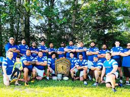 the Manu Bears rugby team, shows team officials and players posing for a photo