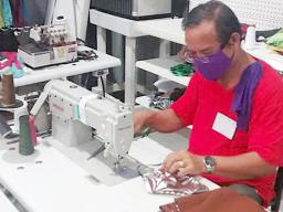 A worker at Manu'a Store sewing protective face masks