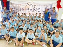 Manumalo students in front of their Veterans Day banner