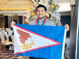 Mataio Suluai carrying the American Samoan flag