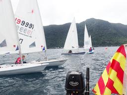 Laser sailors sitting at the ready waiting for the start flag to drop