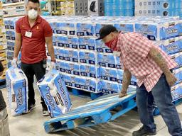 Two store employees stocking toliet paper