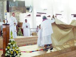 Bishop-elect Kolio Tumanuwao Etuale (kneeling as he is covered by a fine mat)
