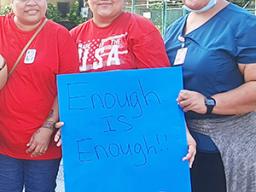Three nurses with sign