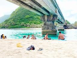 People swimming and relaxing under the Asaga Bridge