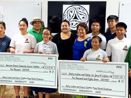 Students of Onnuri Piano Academy — together with members of American Samoa's Korean and Chinese Associations, and the Korean and Chinese Community Youth Groups — pictured with two checks
