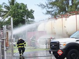 Firemen spraying water on storage tanks