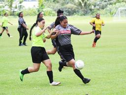 A Pago Youth player challenges a Taputimu Youth defender