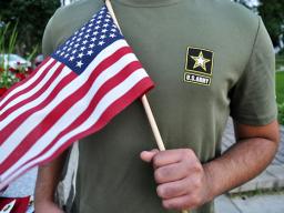 a Pakistani recruit, 22, who was recently discharged from the U.S. Army, holds an American flag as he poses for a picture. The man asked his name and location to be undisclosed for safety reasons. The AP interviewed three recruits from Brazil, Pakistan and Iran, all of whom said they were devastated by their unexpected discharges