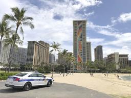  a police officer arrives to tell people to leave Waikiki Beach