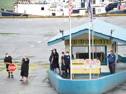 Port Administration and other ASG personnel at the entrance to the Port of Pago Pago stand guards with their masks, as security is tight at the dock due to a vessel in port with three confirmation COVID-19 cases. 