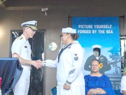Rear Adm. Richard Meyer gives coin to Navy Counselor 1st Class Alesana Faanofoilefagaoalii
