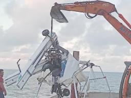 plane crash debris being lifted from the sea