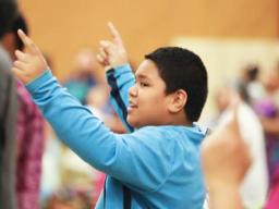 A young boy joins in singing praises to God at the Pacific Northwest Samoan Camp Meeting held at Sunset Lake Camp. Youth and adults alike participated in a training session on blending faith and culture