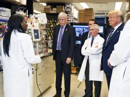 Dr. Kizzmekia Corbett, left, senior research fellow and scientific lead for coronavirus vaccines and immunopathogenesis team in the Viral Pathogenesis Laboratory, talks with President Donald Trump 