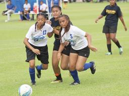 Two Samoana players defend against a Fa’asao-Marist opponent 