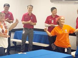 Members of the Starkist Samoa management team celebrate  Ms. Loretta Mika's years of service as she does the taualuga