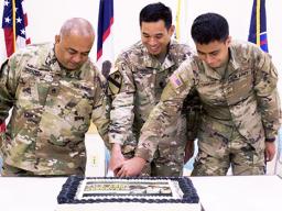 Staff Sgt. Faiupu Tagaleoo, assigned to Theater Support Group American Samoa Detachment, 9th Mission Support Command (left), representing the oldest unit member, and Pvt. Vend Luafutu, assigned to Charlie Company, 100th Battalion, 442nd Infantry Regiment, 9th Mission Support Command (right), along with Lt. Col. Alejandro Buniag, Commander, Theater Support Group American Samoa Detachment