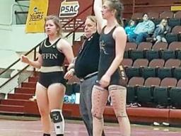 Stephanie Floor with her arm upraised after wrestling victory