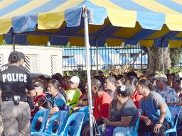 Crowds of people under tent waiting to cash stimulus checks