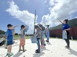Students and teacher looking at clouds in the sky