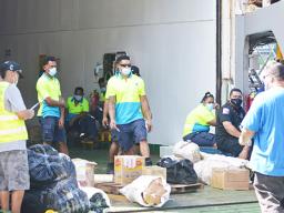 Bags of taro being unloaded at wharf.
