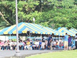 Crowds of people waiting under tents at TBAS to cash their stimulus checks