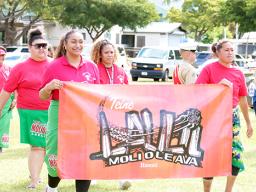 Teine Laulii Hawaii members marching with banner