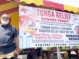 Paea Mateitalo Amelia in front of Tonga fundraiser banner