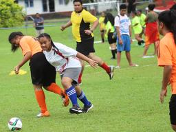 A Vaiala Tongan player dribbles by an Utulei Youth defender 