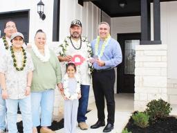 Retired U.S. Army Sergeant First Class Vaitogi Sani Taetuli and his family in front of their new home.