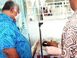 Prime Minister Tuilaepa Sailele Malielegaoi in a mask with sick child