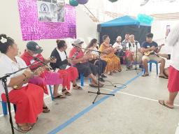 Senior citizens, students and others playing ukulele