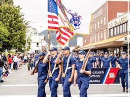 Leonrhee K. Alaimaleata carrying USCG flag in formation