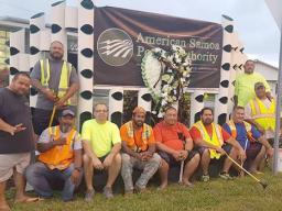 ASPA staff posing in front of wreath for Executive Director Utu at ASPA entrance 