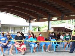 Inter-island wharf with people waiting for cargo under new system