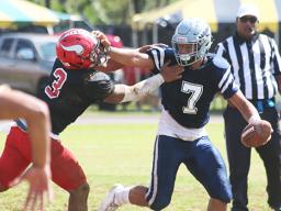 Samoana Sharks quarterback Viliamu Tanielu trying to hold off a vicious blitz by Ronnie Oa of