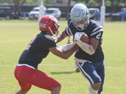 Samoana Sharks wide receiver Avery Seumanutafa trying to escape a tackle by Fitu Amata