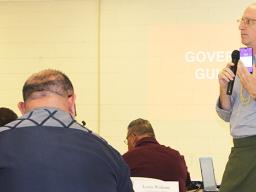 ASTCA CEO Wolman holds up for cabinet members one of the new ASTCA mobile phones