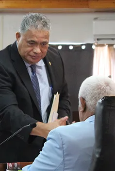 Health director Motusa Tuileama Nua shaking hands with a senator