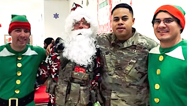 Senior Airman Oto with Santa and his elves