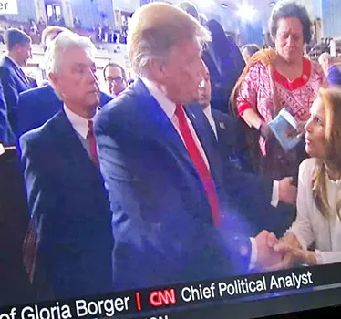 Donald Trump leaving in the House chamber with Aumua Amata in the background.