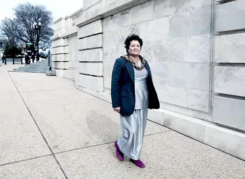 Amata outside in Washington D.C. walking toward her office building.