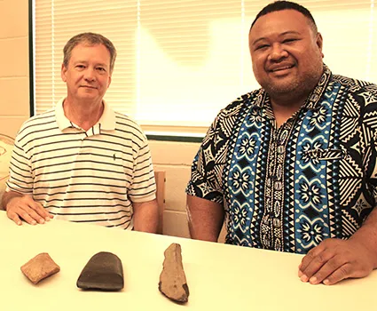 Earl Andersen (left) and Territorial Librarian, Justin Maga pictured yesterday at the Feleti Barstow Public Library where Andersen, on behalf of the Rev. Fred Andersen family, returned to the territory what appear to be stone artifacts 