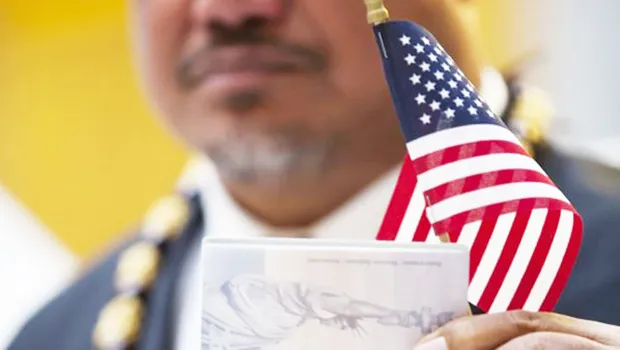John Fitisemanu, in the background holding his U.S. National passport