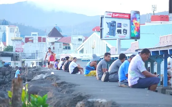 Apia residents sitting on the sea wall