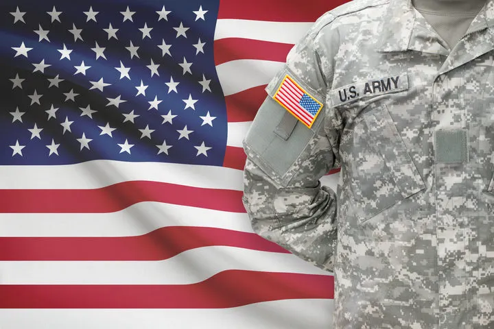Solier standing in front of American flag.